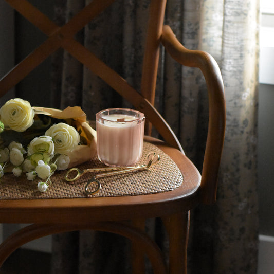 Wicker chair with a small table and decorative items on a patterned rug